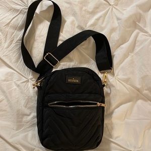 Crossbody quilted black purse with adjustable strap. Outside zipper pocket.